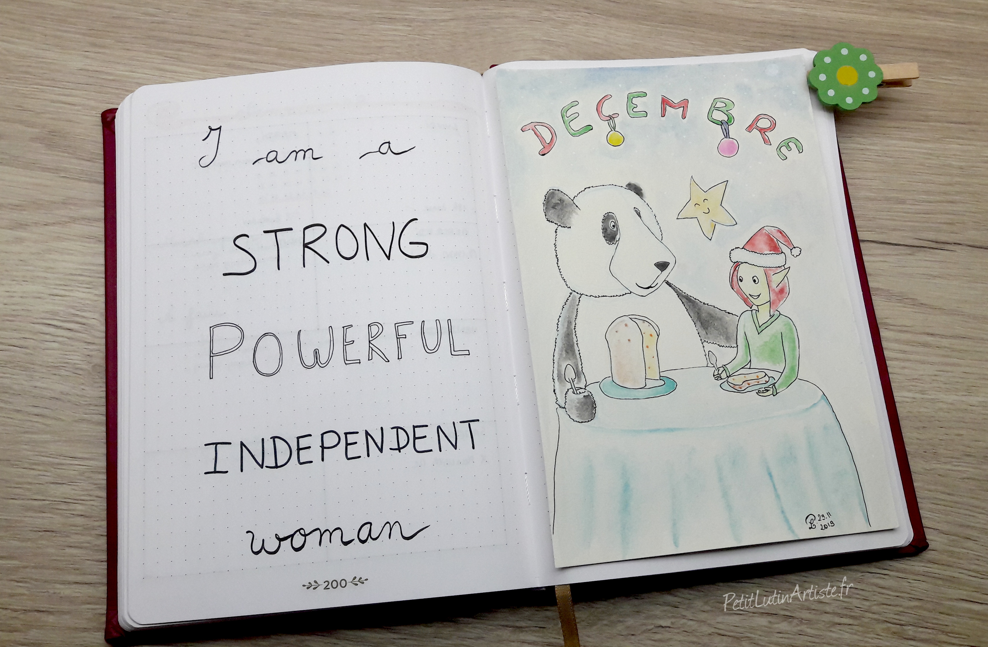 belette journal plan with me decembre 2019 : page de gauche phrase inspirante "I am a strong powerful independent woman", à droite aquarelle de Moustache le panda et Petit Lutin qui mangent du panettone, et il y a écrit Décembre en haut